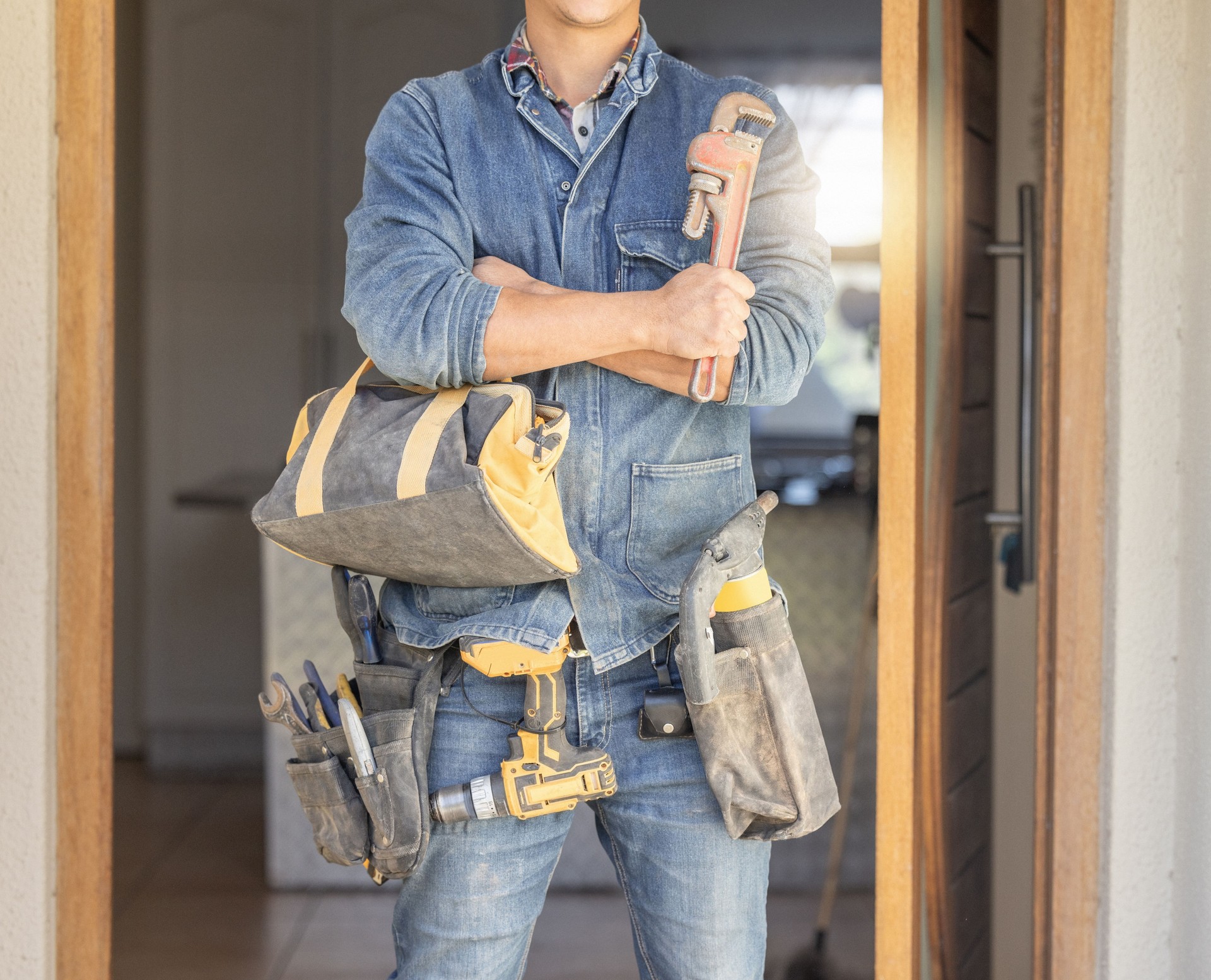 Handyman, tool bag and arms crossed at work with goals, property development and real estate maintenance. Construction worker, tools and renovation industry with service, vision and home improvement